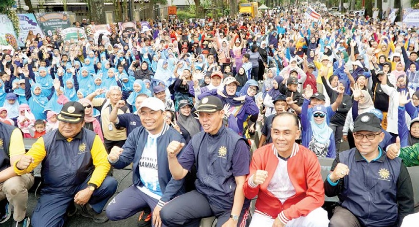 KOMPAK: Ketua PDM Kota Malang Prof Dr Abdul Haris MA (tengah) dan Wakil Wali Kota Malang Ali Muthohirin (dua dari kiri) bersama dengan pengunjung CFD merayakan Milad Ke-113 Muhammadiyah.
