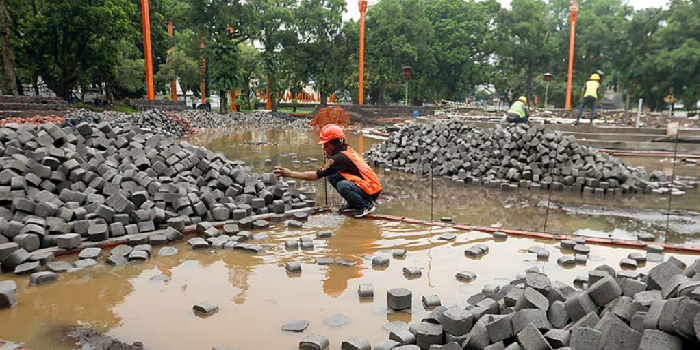 DIKEBUT: Pekerjaan fokus di area air mancur kemarin (23/11). Proyek revitalisasi Alun-Alun Merdeka ditarget tuntas pertengahan Januari 2026.