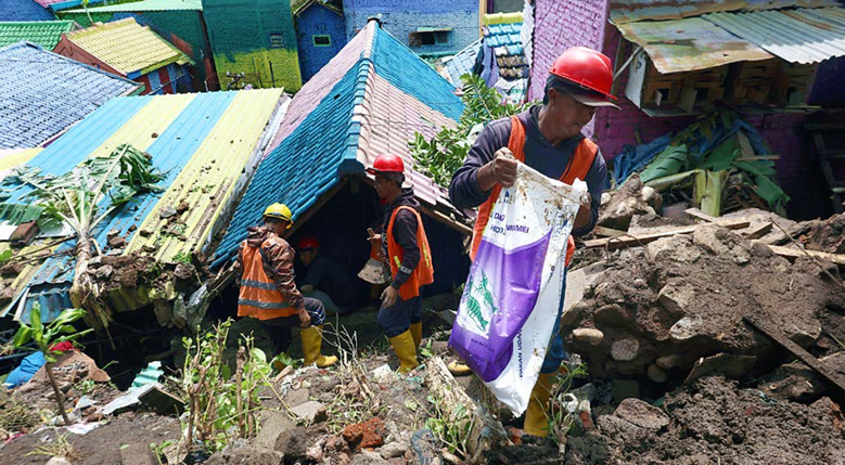 DIBERSIHKAN: Salah satu rumah warga terdampak longsoran dari Jembatan Embong Brantas di Kelurahan Kesatrian, Kecamatan Blimbing.