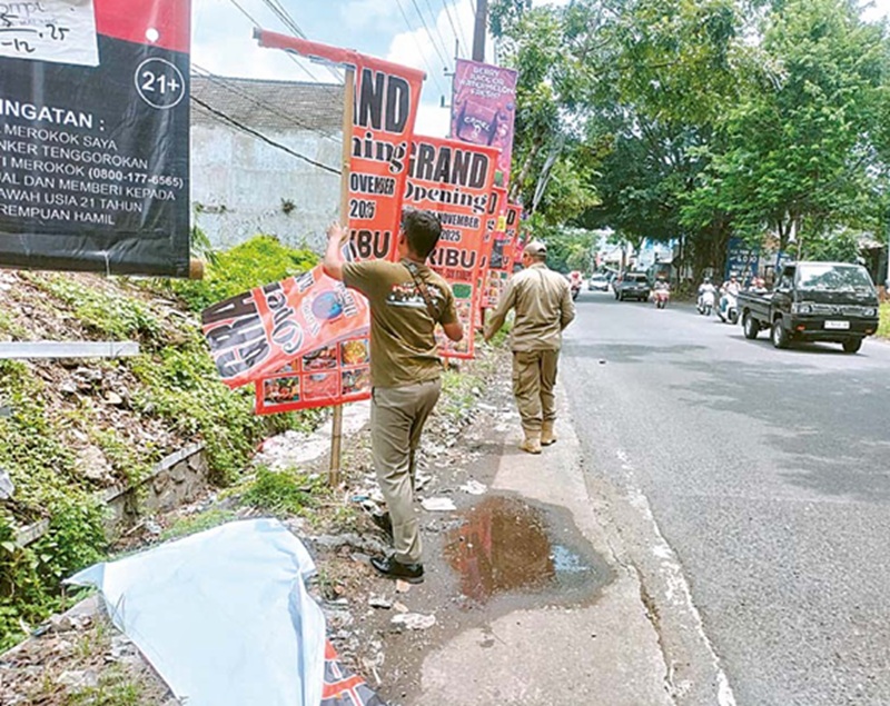 TINDAK TEGAS: Personel Satpol PP Kabupaten Malang menertibkan reklame di Singosari dan Karangploso kemarin (25/11).