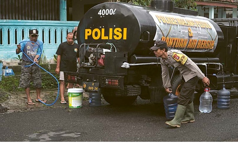 BANTU MASYARAKAT: Beberapa personel dari Polsek Lawang mendistribusikan air bersih di Dusun Krajan, Desa Sumberngepoh, Kecamatan Lawang kemarin (26/11).