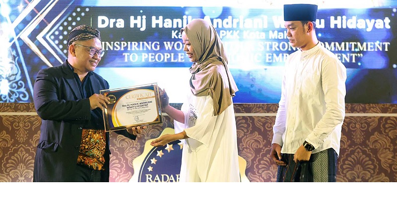 BANYAK BERJASA: Direktur Jawa Pos Radar Malang Tauhid Wijaya (kiri) menyerahkan piagam penghargaan khusus kepada Nabilla Febrina, putri dari almarhumah Hanik Andriani, Rabu malam (26/11).