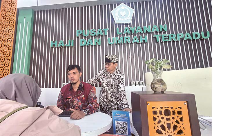 URUS ADMINISTRASI: Petugas Kemenag Kota Malang melayani seorang CJH yang melunasi biaya haji kemarin.