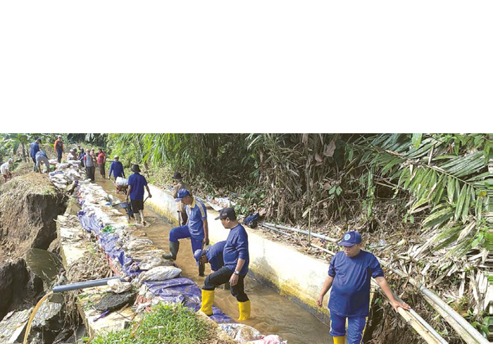 DEMI SAWAH PETANI: Tim DPUSDA Kabupaten Malang dan Himpunan Petani Pemakai Air (HIPPA) menangani bencana longsor dengan karung plastik dan terpal pada saluran irigasi di Desa Plaosan, Kecamatan Wonosa