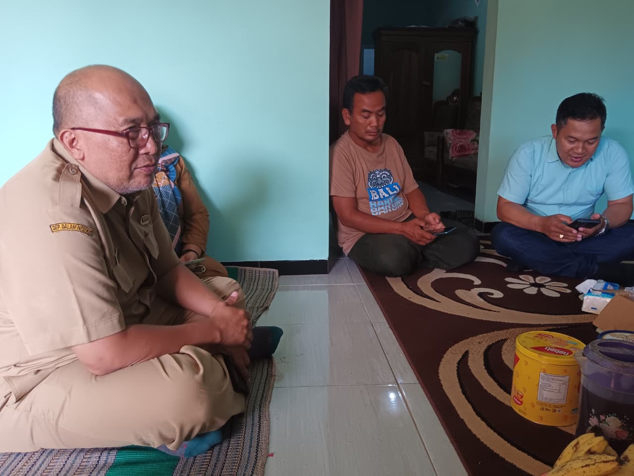 Kabid Penempatan Tenaga Kerja Disnaker Kabupaten Malang Tri Darmawan (kiri) mendatangi rumah keluarga TKI yang menjadi korban kebakaran apartemen di Hongkong, Senin (1/12). (Indah Mei Y./Radar Malang)