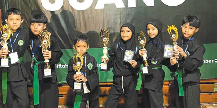 ON FIRE: Siswa-siswi MI Miftahul Huda Sukolilo mendapatkan trofi setelah berhasil menjadi juara dalam Kejuaraan Pencak Silat Garuda Juang I.