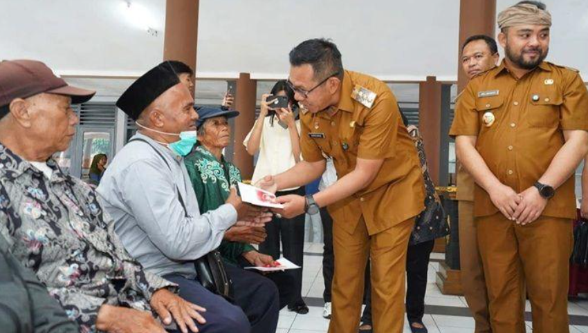 SAMPAIKAN AMANAH: Wali Kota Batu Nurochman menyampaikan bantuan PKH Plus kepada salah satu warga di Pendapa Kecamatan Bumiaji, kemarin (16/9).