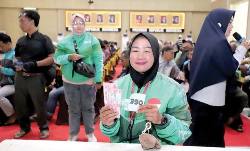 TERIMA BANTUAN: Salah seorang driver ojol menerima bansos di Gedung Graha Pancasila beberapa waktu lalu.