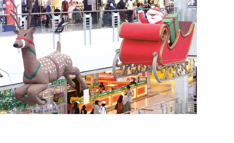 DOMINAN MERAH: Kereta Sinterklas menggantung di auditorium Mal Olympic Garden (MOG) untuk menambah nuansa natal menjelang Nataru.