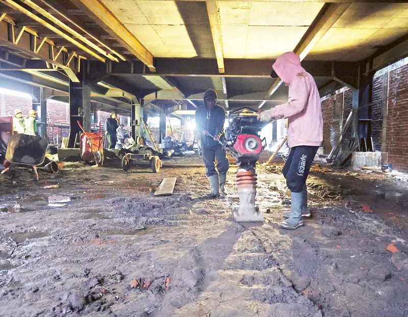 DIKEBUT: Para pekerja yang membangun gedung parkir kajoetangan memadatkan lantai bawah sebelum dipasang keramik kemarin (2/12).