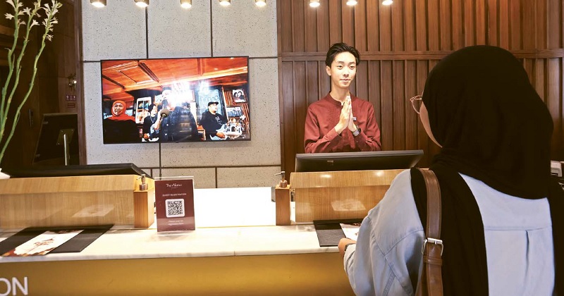 MULAI PULIH: Seorang resepsionis Hotel Alana menyapa tamu yang hendak menginap kemarin (3/12) siang. Deretan event yang digelar sejak Oktober mendongrak keterisian kamar hotel.