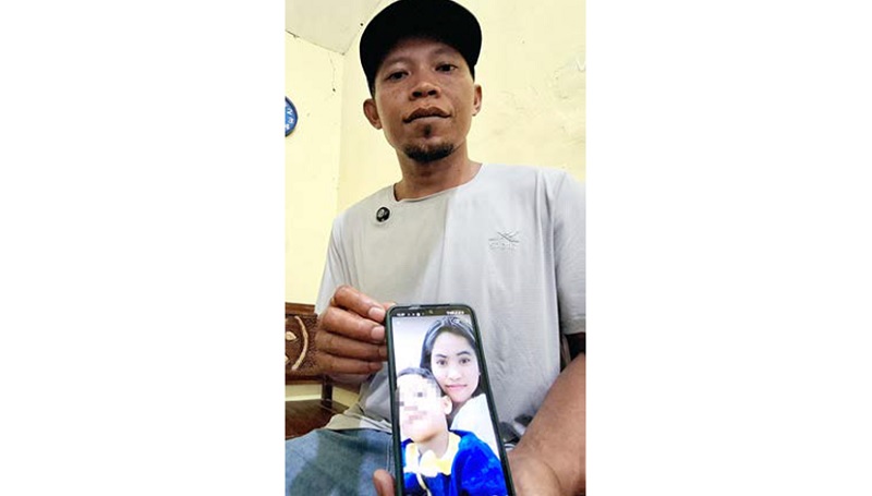 MASIH BERDUKA: Suyitno, 39, menunjukkan foto Erawati menggendong anaknya kemarin (3/12). Dia meninggal dalam kebakaran di apartemen Hongkong, tempatnya bekerja.