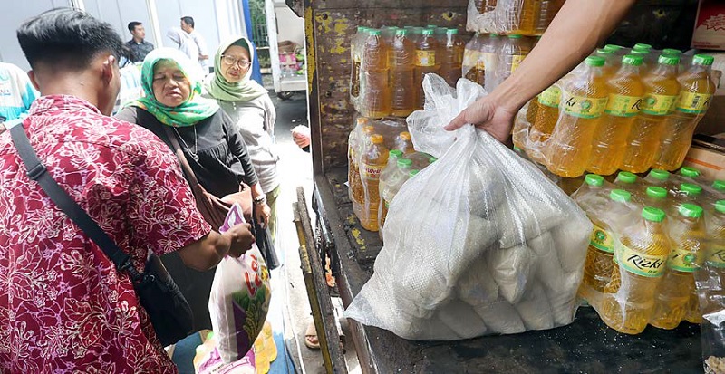 ANTUSIASME: Warga antre membeli kebutuhan pokok dengan harga miring saat Gerakan Pangan Murah (GPM) di halaman Balai Kota Malang kemarin (4/12).