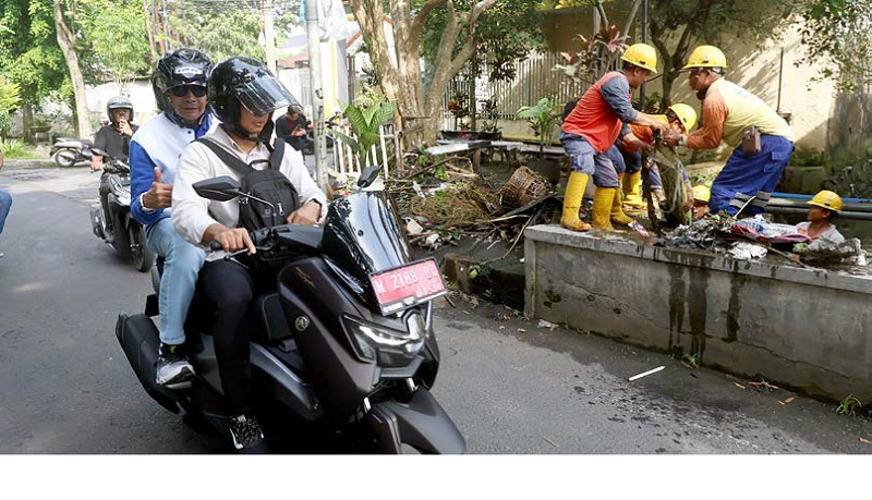 LANGGANAN GENANGAN: Wali Kota Malang Wahyu Hidayat dibonceng dengan motor untuk meninjau kerja bakti di Jalan Kediri, Kelurahan Gadingkasri, Klojen, kemarin.