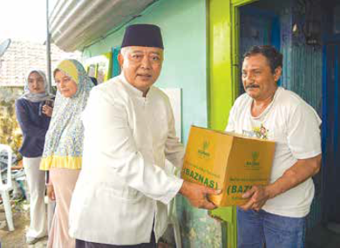 PEDULI SESAMA: Bupati Malang H M. Sanusi (kiri) memberikan bantuan kepada keluarga korban yang terdampak kejadian longsor di RT 03 RW 04, Desa Mulyorejo, Kecamatan Lawang, kemarin.