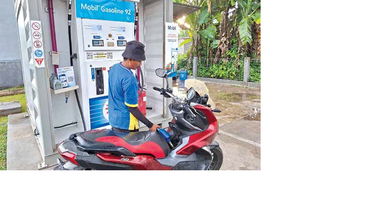 LEBIH TERJANGKAU : Operator SPBU Mini Mobil di Jalan Luhur, Kelurahan Penarukan, Kecamatan Kepanjen, mengisi bahan bakar milik konsumen kemarin siang (7/12).