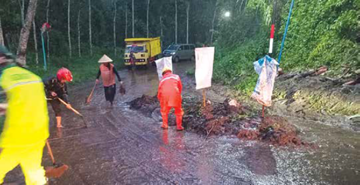 LANGSUNG DIBERSIHKAN: Jalan Raya Desa Pandansari, Kecamatan Poncokusumo sempat tertimbun longsoran pada Minggu sore (7/12).