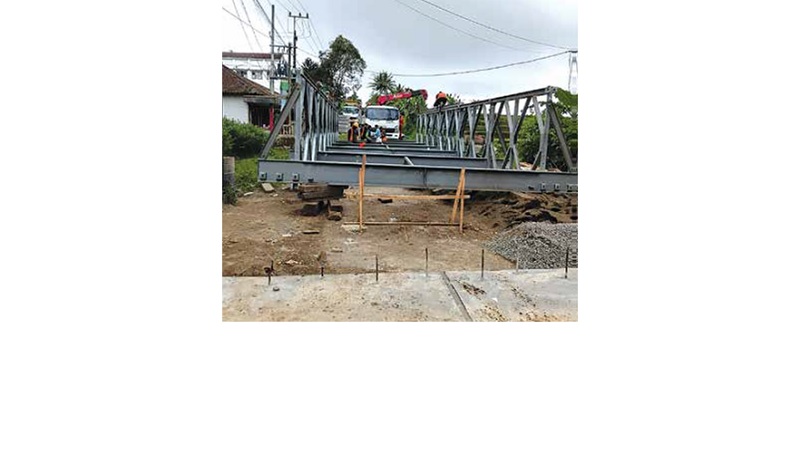 BUTUH DUA PEKAN: Material jembatan bailey sudah tiba di Jalan Hasanudin, Desa Donomulyo, Kecamatan Donomulyo sejak Minggu pagi (7/12).