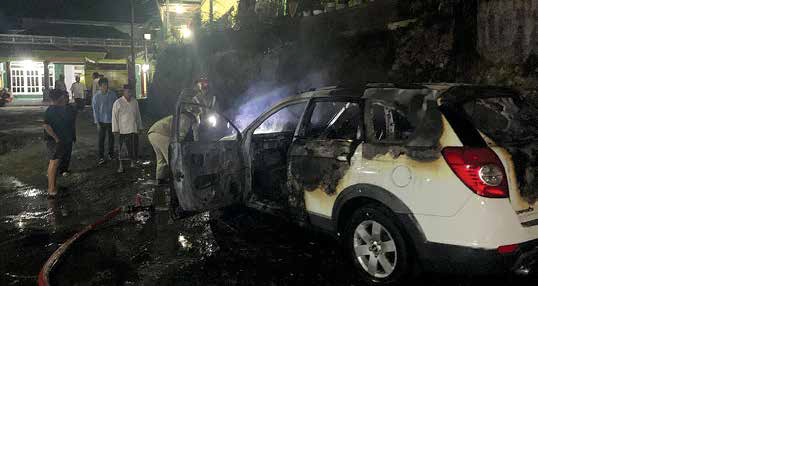 DIDUGA KORSLETING: Pemadaman mobil Chevrolet Captiva di Desa Kromengan, Selasa malam (8/12) membuat dua personel Damkar Kabupaten Malang dilaporkan mengalami luka ringan.