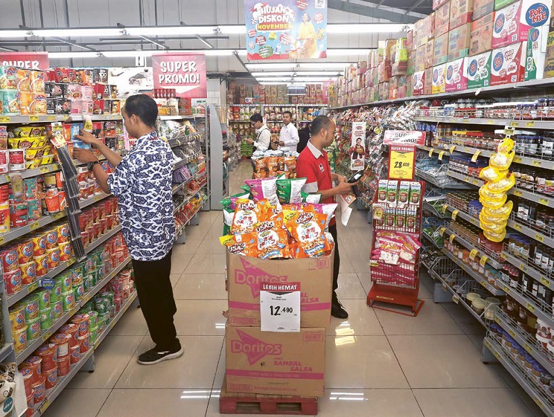 PENUHI KEBUTUHAN POKOK: Pengunjung supermarket di Jalan Langsep, Klojen, memilih bahan makanan kemarin siang.