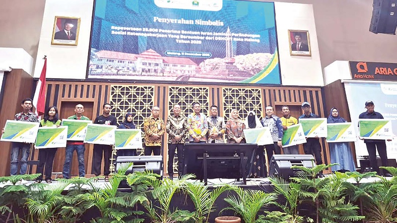 TERJAMIN: BPJS Ketenagakerjaan Cabang Malang bersama Pemkot Malang menyerahkan bantuan iuran jamsostek kepada pekerja informal kemarin.