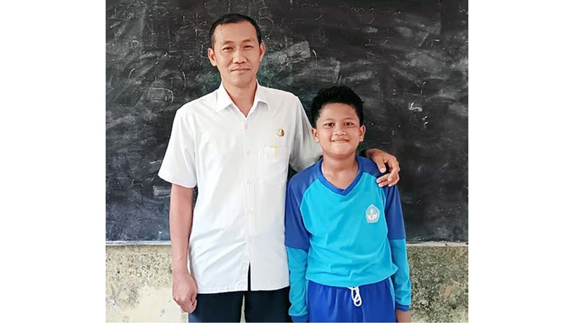 PENGABDIAN: Guru SDN 6 Sumberpetung Dedi Hermawan bersama Ilham Mahendra, siswa satu-satunya yang dia ajar di kelas 5. Setiap mengajar dia selalu punya cara agar Ilham nyaman belajar di kelas.