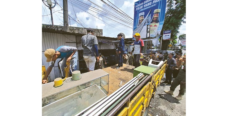 SUDA H DIBERI PERINGATAN: Pembongkaran terhadap salah satu warung di pinggir Jalan Raya Desa Tunjungtirto, Singosari dilakukan tim gabungan dari Satpol PP Jatim dan Kabupaten Malang, kemarin.