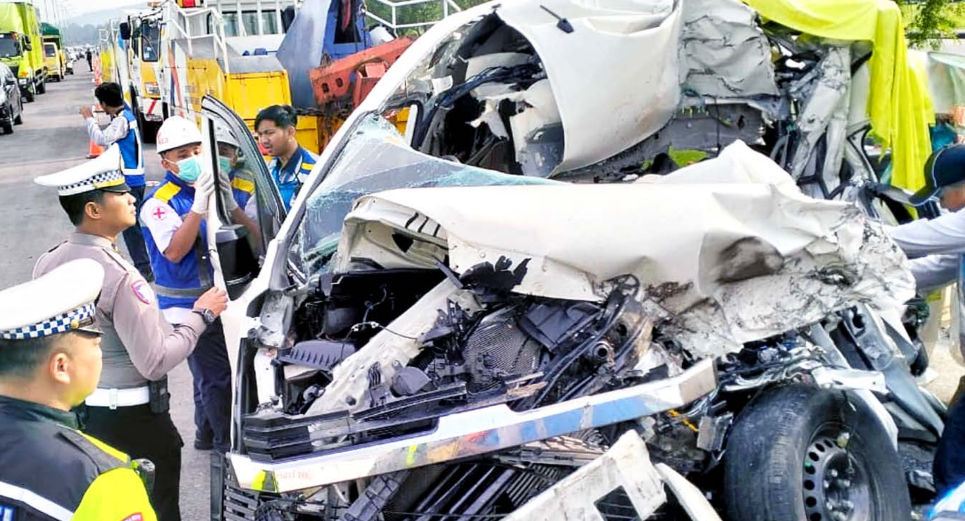 ROMBONGAN WISATAWAN: Bagian depan mobil Hiace ringsek kemarin (13/12). Beberapa personel Satlantas Polresta Malang Kota melakukan olah TKP untuk mengetahui penyebab kecelakaan.