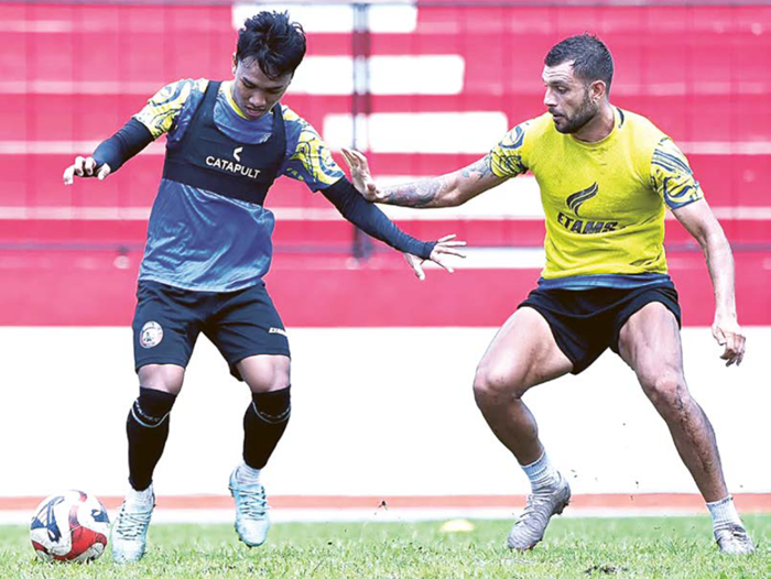 HARUS MOVE ON: Gelandang Arema FC Arkhan Fikri (kiri) berusaha melewati Ian Puleio dalam sesi latihan di Stadion Gajayana, Kamis lalu (11/12).