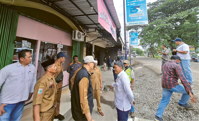 DIKELUHKAN WARGA: Petugas dari DPUBM Kabupaten Malang bersama pelaksana proyek Inpres Jalan Daerah Kepanjen-Pagak meninjau lokasi raising road di Jalan Sumedang, kemarin.