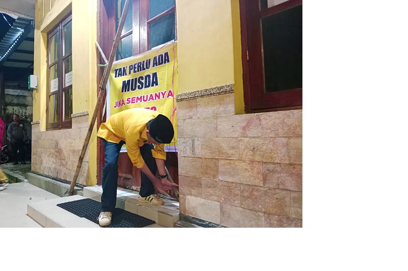 KECEWA: Salah satu kader Partai Golkar berada di kantor DPD Partai Golkar Kota Malang yang sudah disegel kemarin malam (14/12).