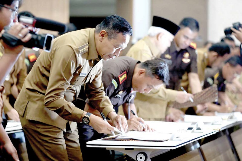 TEKEN BERSAMA: Wali Kota Malang Wahyu Hidayat bersama Kepala Kejaksaan Negeri Kota Malang Tri Joko menandatangani kerja sama penerapan pidana kerja sosial di Fakultas Hukum Unair, Senin (15/12).