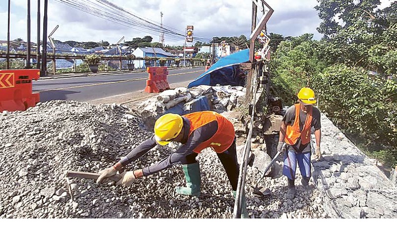 TERUS DIKEBUT: Pekerja menyelesaikan perbaikan trotoar Jembatan Embong Brantas dengan pemasangan bronjong dan penguatan struktur penahan tanah, kemarin (17/12).