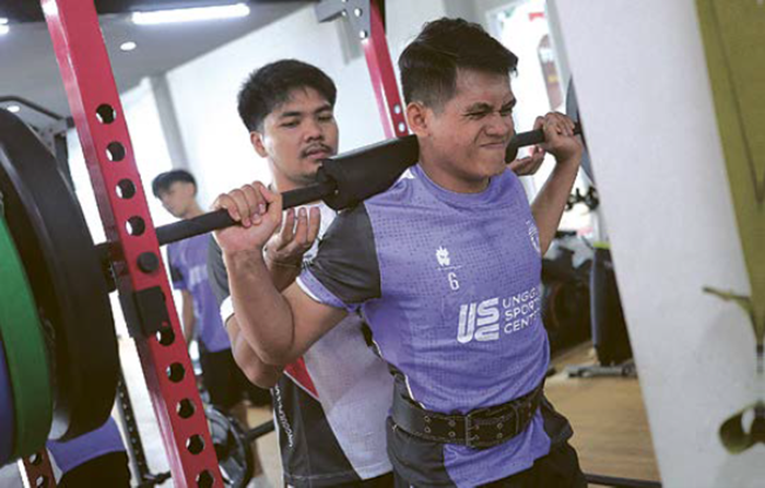 MAKSIMALKAN PELATIH: Eks Pelatih Fisik Unggul FC Malang Abdul Manan membantu Andres Dwi Persada dalam sesi latihan angkat beban di gym Unggul Sports Center, beberapa waktu lalu.