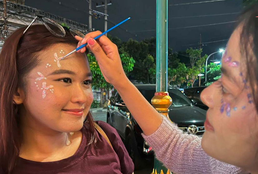 LAGI TREN: Seorang wisatawan melakukan face painting di kawasan Kajoetangan Heritage kemarin malam.