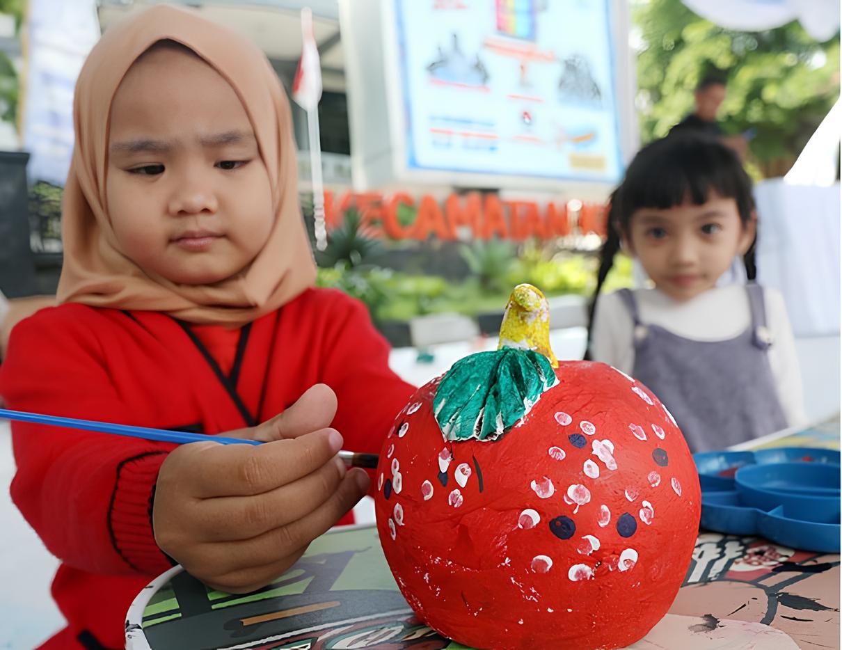 SERIUS: Siswa-siswi TK mewarnai gerabah berbentuk celengan di Jalan Surabaya kemarin (20/12).