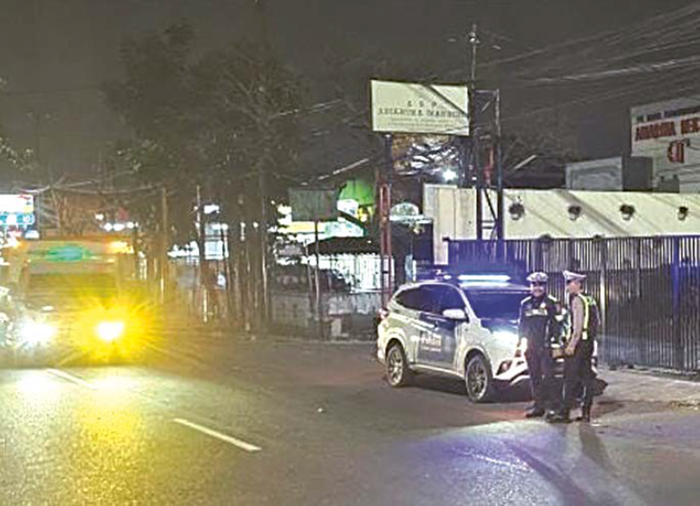 ADA PENINGKATAN: Personel Polres Malang memantau arus lalu lintas di kawasan Karanglo pada Minggu malam (21/12).