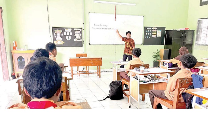 TUNGGU KEPASTIAN: Seorang guru tidak tetap (GTT) menyampaikan materi pelajaran kepada siswa di ruang kelas kemarin.