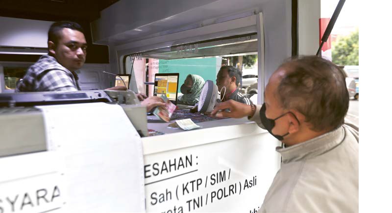 TAAT ATURAN: Warga membayar pajak di samsat keliling area pos polisi Jalan KH Agus Salim, Klojen kemarin (22/12).
