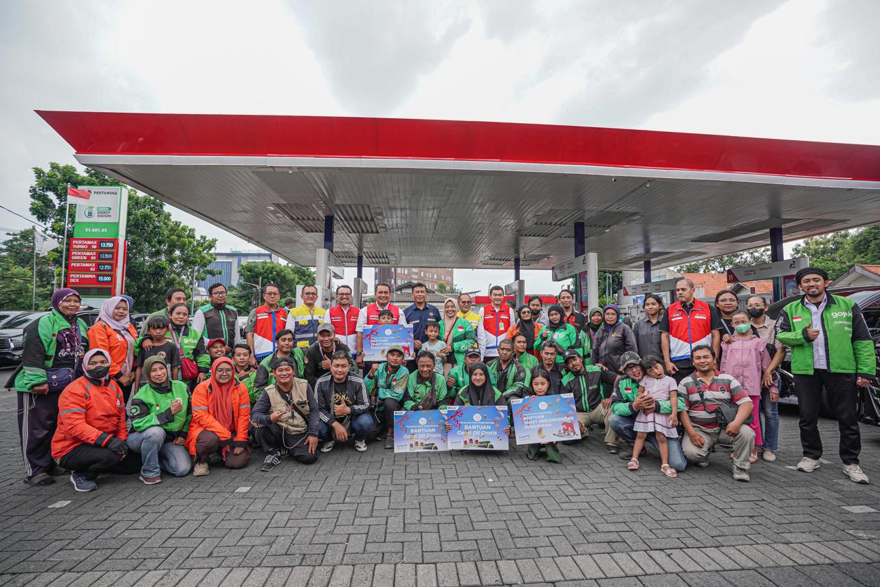 KEBERSAMAAN: Pertamina Patra Niaga menyalurkan bantuan paket alat pendidikan sekolah bagi 500 anak pengemudi ojek online di Surabaya, sekaligus memberikan layanan ganti oli gratis.