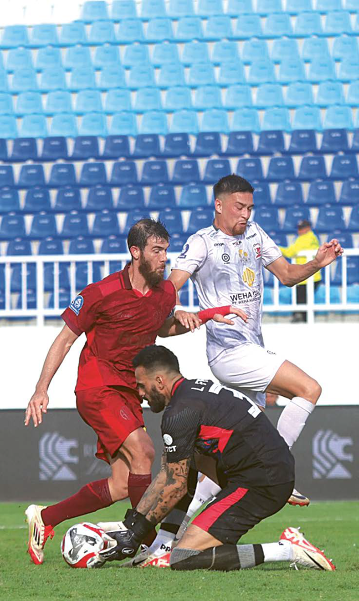 SIGA P: Kiper Arema FC Lucas Frigeri dibantu Luiz Gustavo (kiri) mengamankan bola dari pemain Madura United Jordy Whermann di Staion Kanjuruhan, Kabupaten Malang pada Selasa sore (23/12).