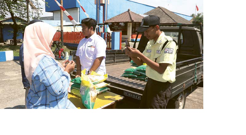 PASTIKAN CUKUP: Salah satu warga memanfaatkan stan penjualan beras SPHP yang dibuka di depan gudang Bulog di Desa Kebonagung, Pakisaji, kemarin.
