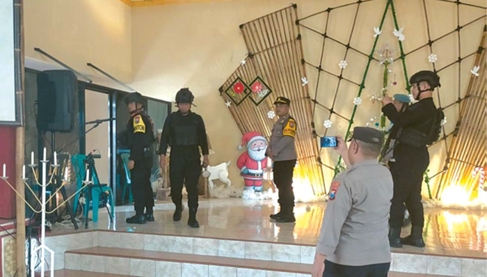 PASTIKAN AMAN: Personel gabungan dari Polres Malang dan Korps Brimob melakukan sterilisasi di GKJW Wonorejo, Dusun Krajan, Desa Wonorejo, Kecamatan Bantur, Rabu sore (24/12).