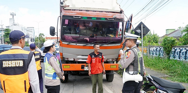 ANTISIPASI LAKA: Personel Satlantas Polres Malang menyosialisasikan pembatasan mobilitas truk sumbu tiga kepada pengemudi di exit tol Lawang kemarin.