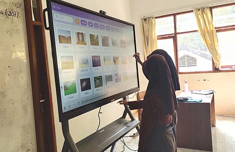 HIBAH DARI PUSAT: Dua pelajar SMPN 3 Kepanjen memanfaatkan papan interaktif untuk pembelajaran, beberapa waktu lalu. Di Kabupaten Malang, sudah ada 2.124 sekolah yang menerima bantuan papan interaktif