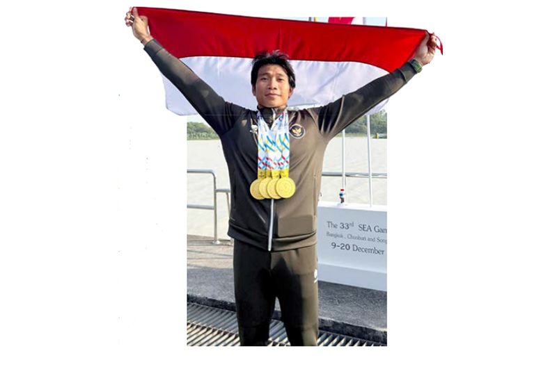 MEMBANGGAKAN: Atlet Dayung asal Sumberpucung, Mugi Harjito membentangkan bendera merah putih setelah meraih emas di ajang SEA Games 2025 di Thailand, 20 Desember lalu.