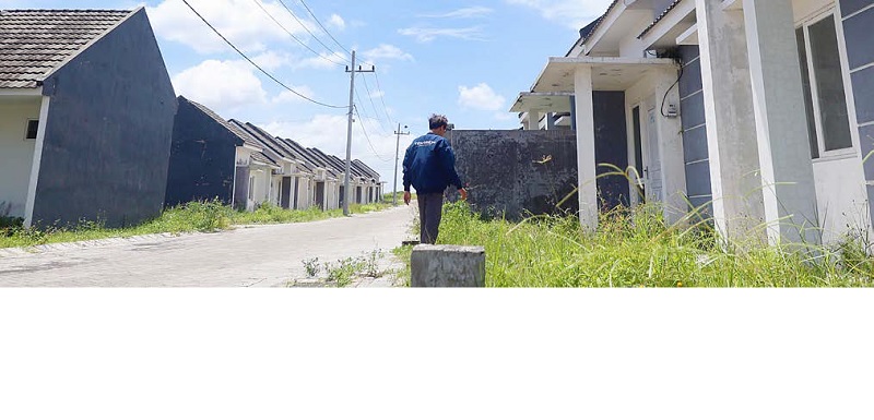 BUTUH BANYAK LAHAN: Seorang warga melintas di perumahan subsidi, Kelurahan Bandulan, Sukun kemarin (29/12). Realisasi program 3 juta rumah untuk MBR terhambat keterbatasan lahan.