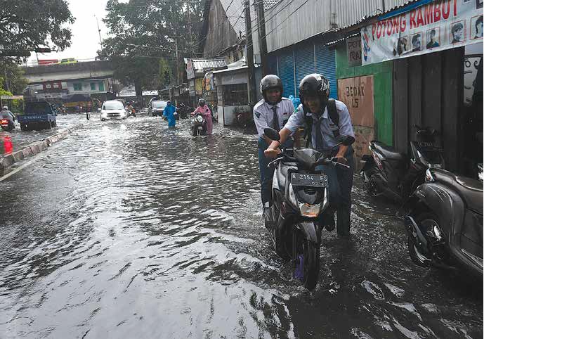 LANGGANAN TERGENANG: Pemotor nekat menerjang banjir yang terjadi di Jalan Sartono, Sukoharjo, Klojen, beberapa waktu lalu.