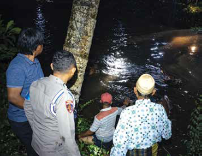 EVAKUASI: Petugas kepolisian bersama warga mengevakuasi jasad laki-laki yang ditemukan mengapung di aliran sungai Molek, Rabu (31/12) malam.