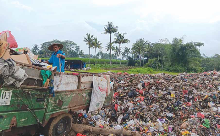 PEMBUANGAN AKHIR: Seorang petugas mengawasi proses pembuangan sampah di TPA Talangagung, Kecamatan Kepanjen, kemarin siang.